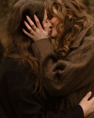 A series of intimate close-up shots showing hands caressing through curly brown hair against a dark background.