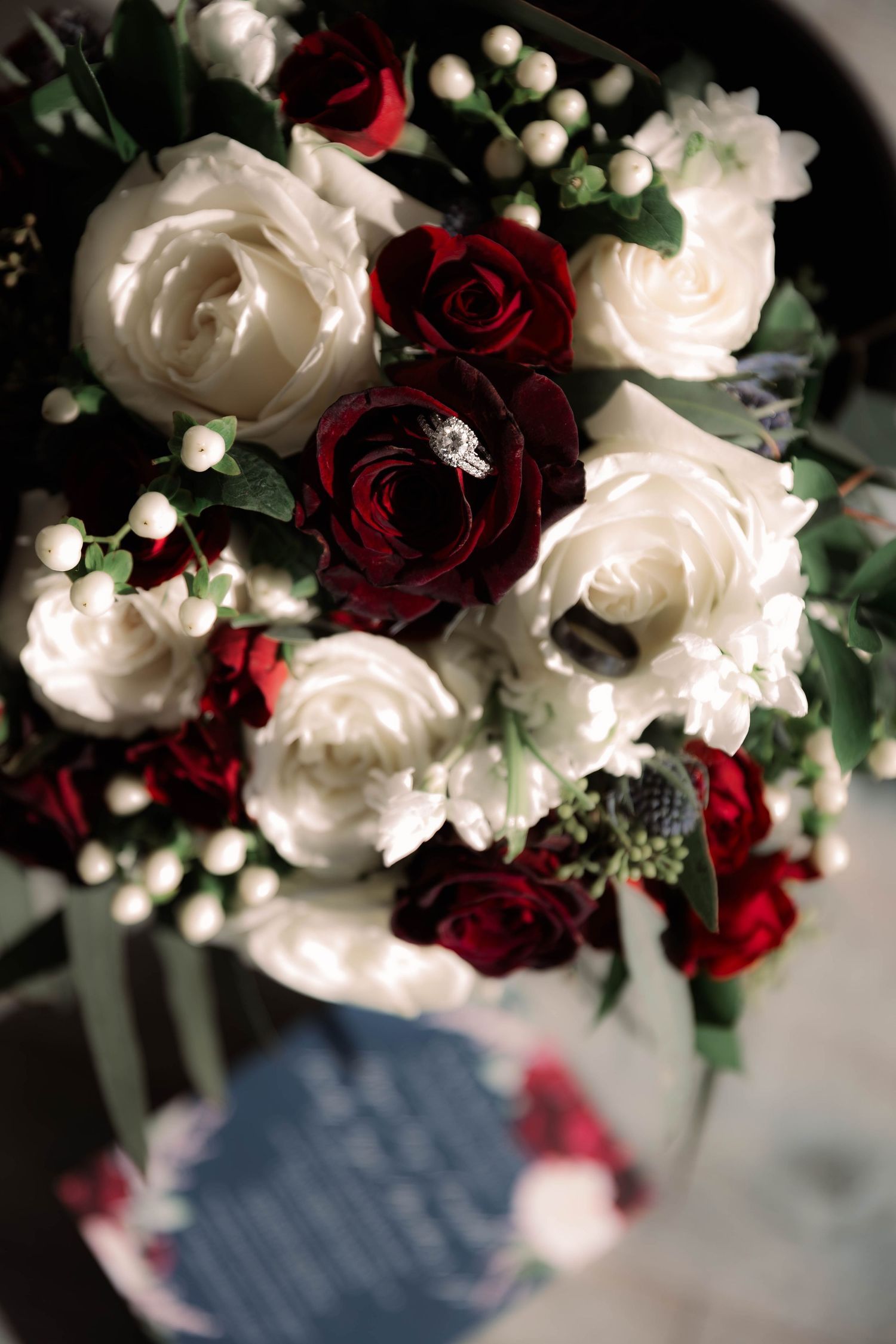 Elegant wedding floral arrangement featuring white and deep red roses with delicate baby's breath.