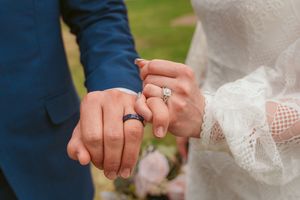 Close-up shots of newlyweds' hands showing their wedding rings during an outdoor photo session.