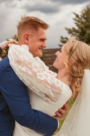 A candid sequence of wedding moments showing affectionate embraces against a cloudy sky.