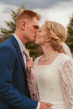 An intimate portrait of a couple in wedding attire with delicate lace details and a navy suit.