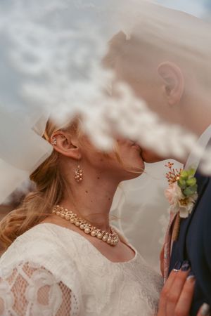 An intimate romantic moment at a wedding captured through dreamy soft focus with delicate lace and jewelry details.