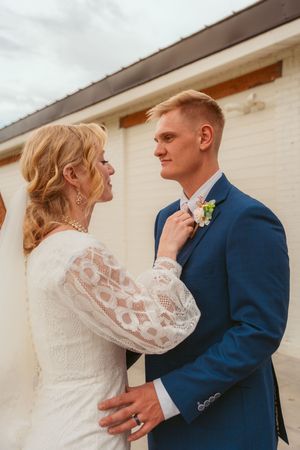 A sequence of intimate wedding portraits shows tender moments between a couple against a white building exterior.