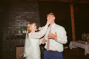 Wedding couple dancing intimately in a dimly lit venue with brick walls.