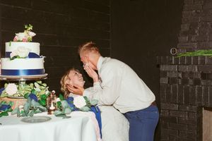 A couple playfully smashes cake into each other's faces at their wedding reception.