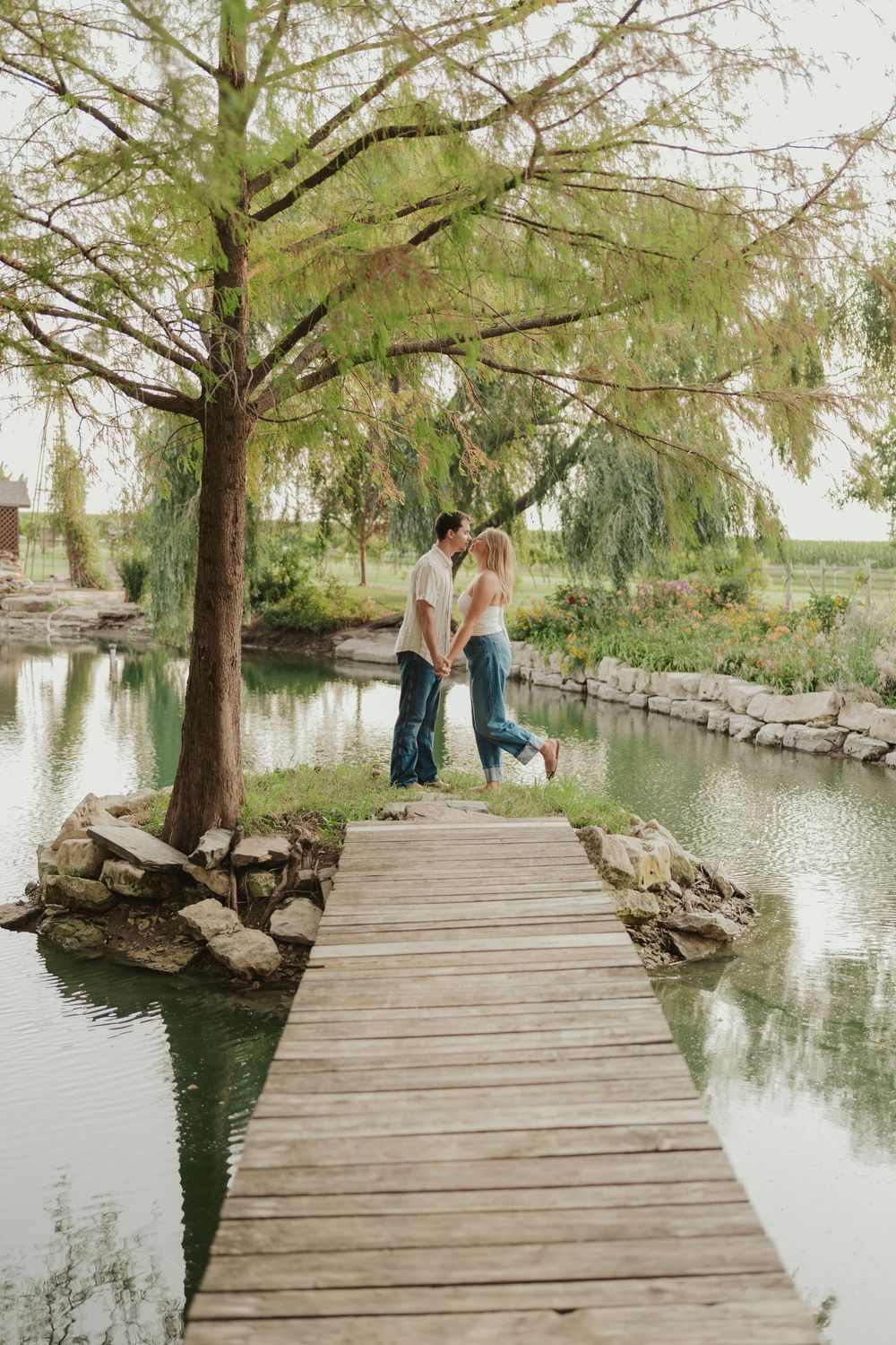 Peaceful couples photo on wooden dock with reflection pond and trees