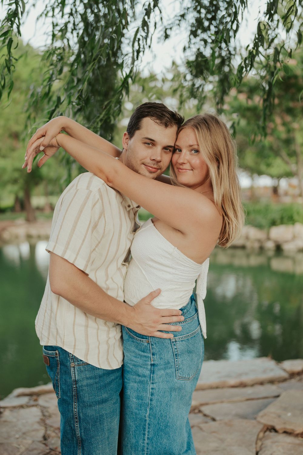 Romantic couples photo by pond under willow tree in Wichita at golden hour