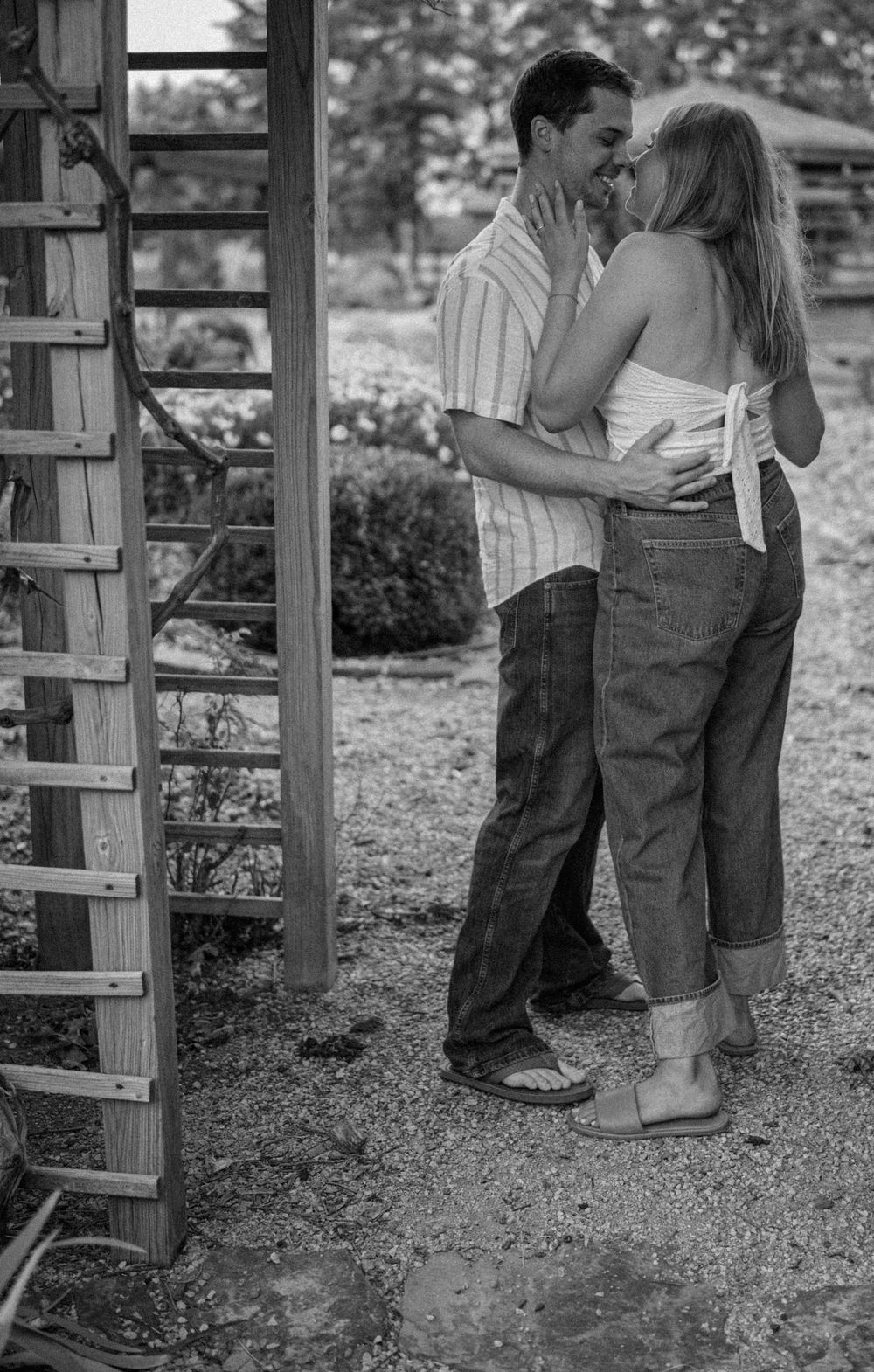 Romantic garden photo of couple under rustic wooden trellis in Kansas