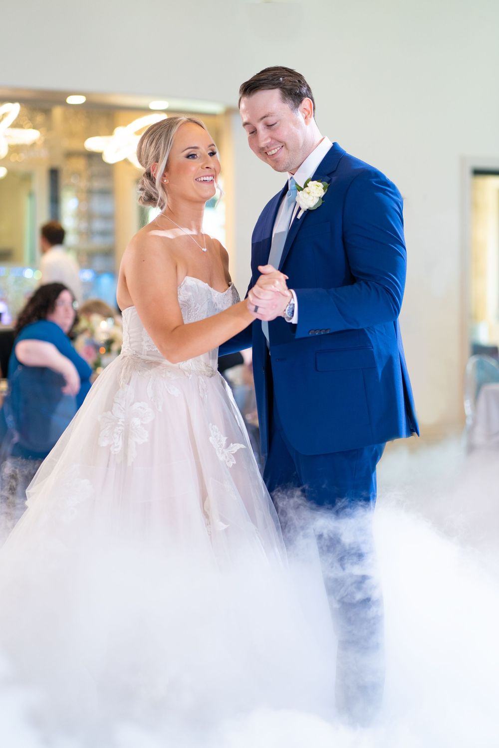 Couple sharing their first dance surrounded by romantic fog effects.