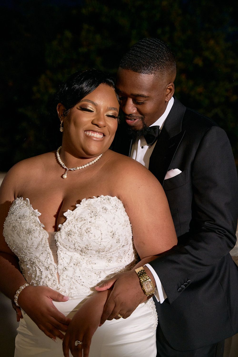 Newlyweds sharing a joyful moment in formal wedding attire.