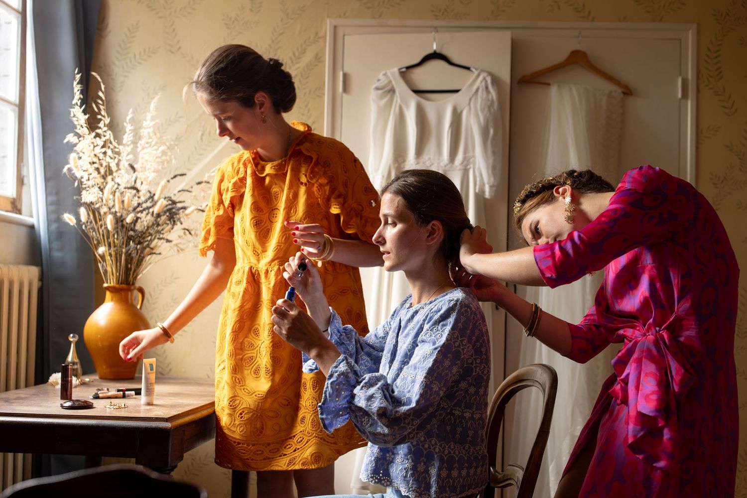 femme qui se maquille avec ses amis le jour de son mariage