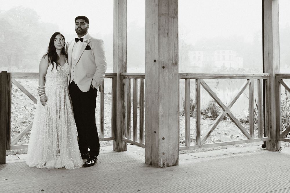 A bride and groom pose elegantly on a wooden deck in black and white wedding portrait photography from Montalto Estate Co.Down