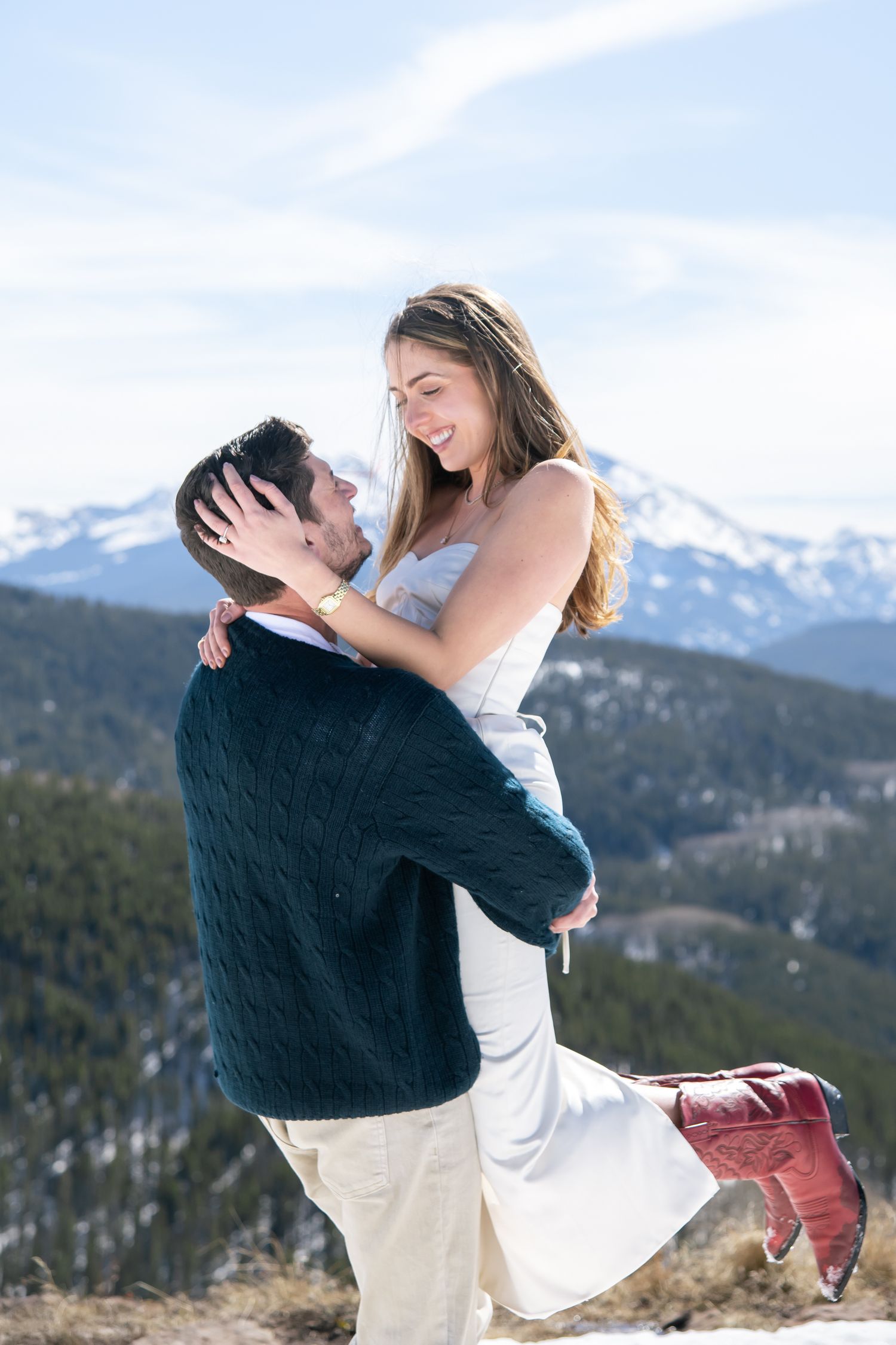 Cute couple holding hands in the snow with mountain views for Vail Colorado engagement photo session.