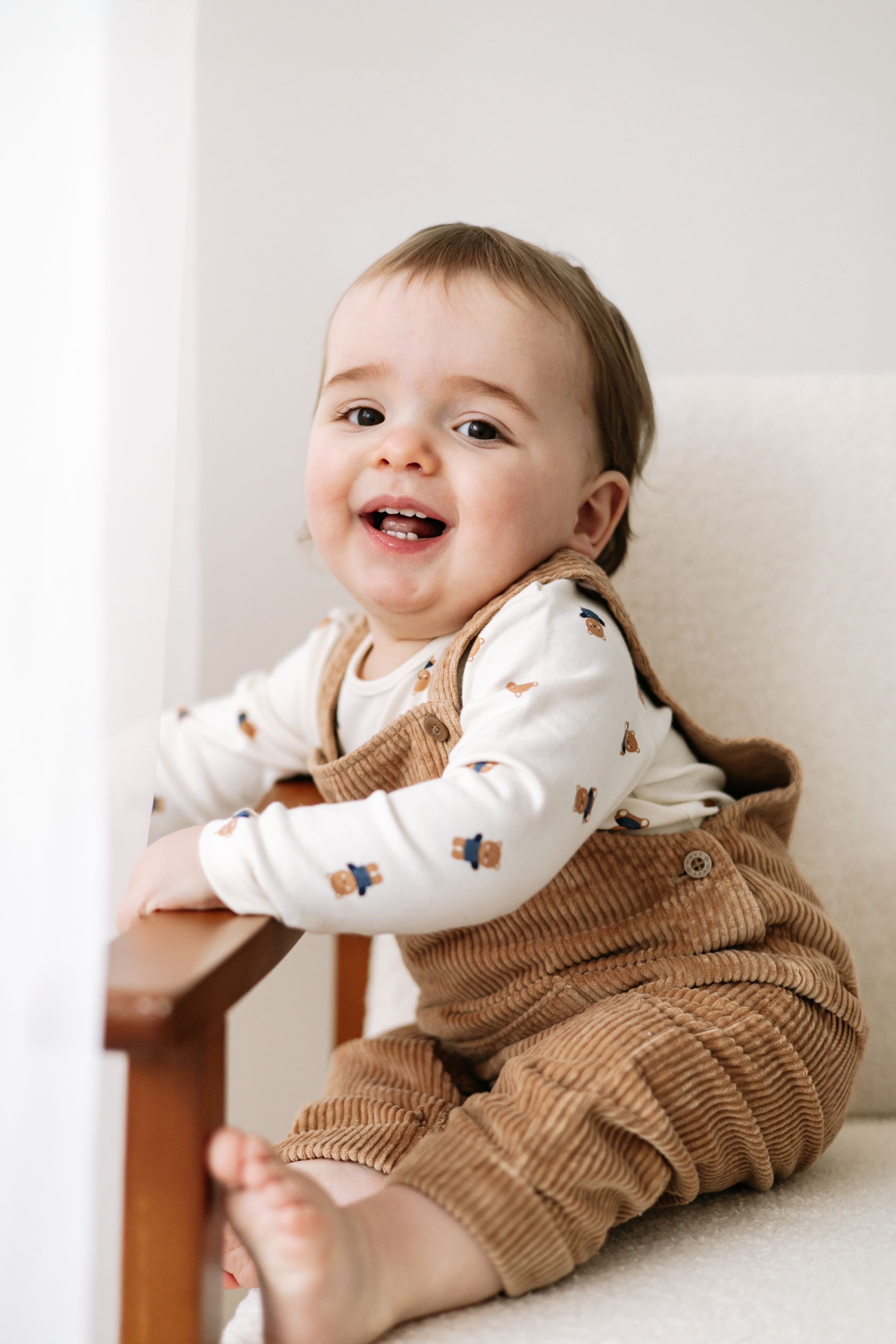 Smiling baby sitting on chair first birthday photoshoot Nottingham