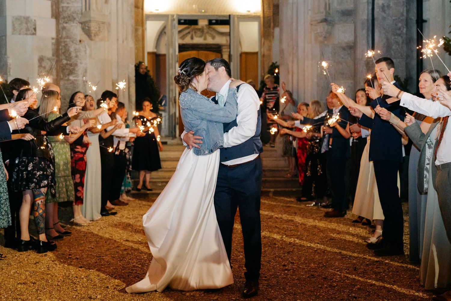 Couples dance together during a romantic evening reception in an elegant ballroom with warm lighting and ornate decor.