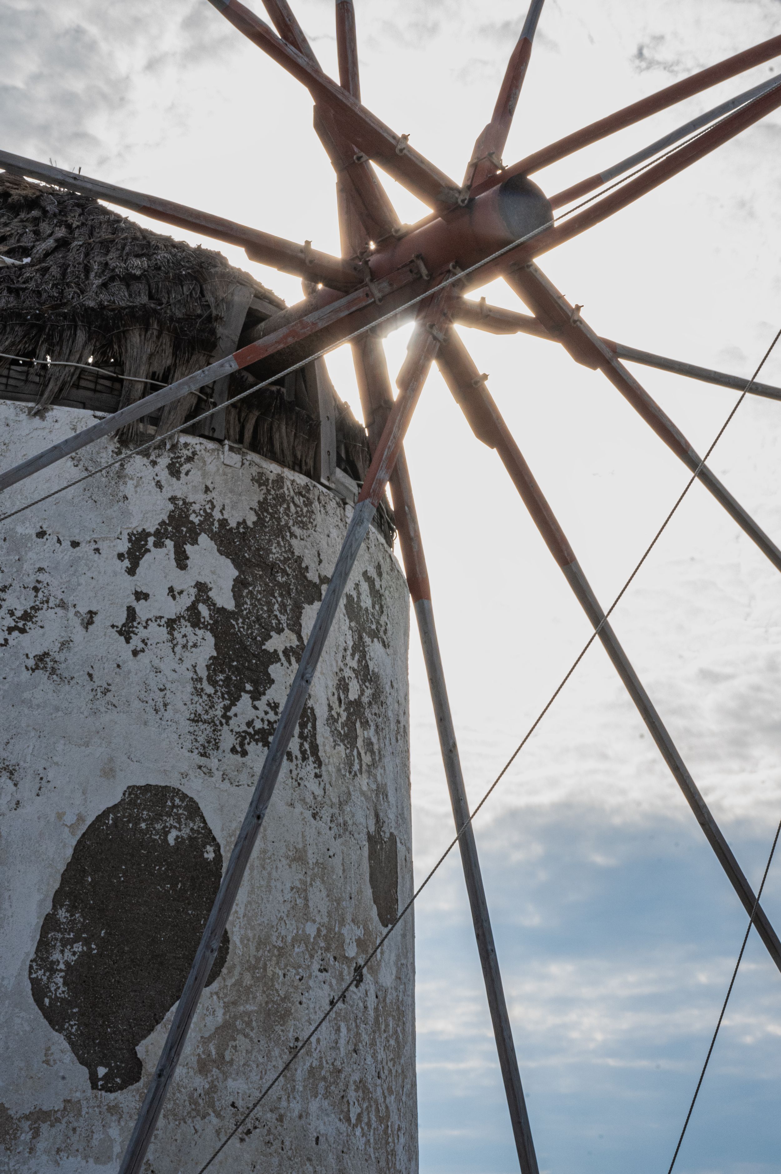 Low angle view of wooden beams against a cloudy sky showing weathered architectural details and structural elements.