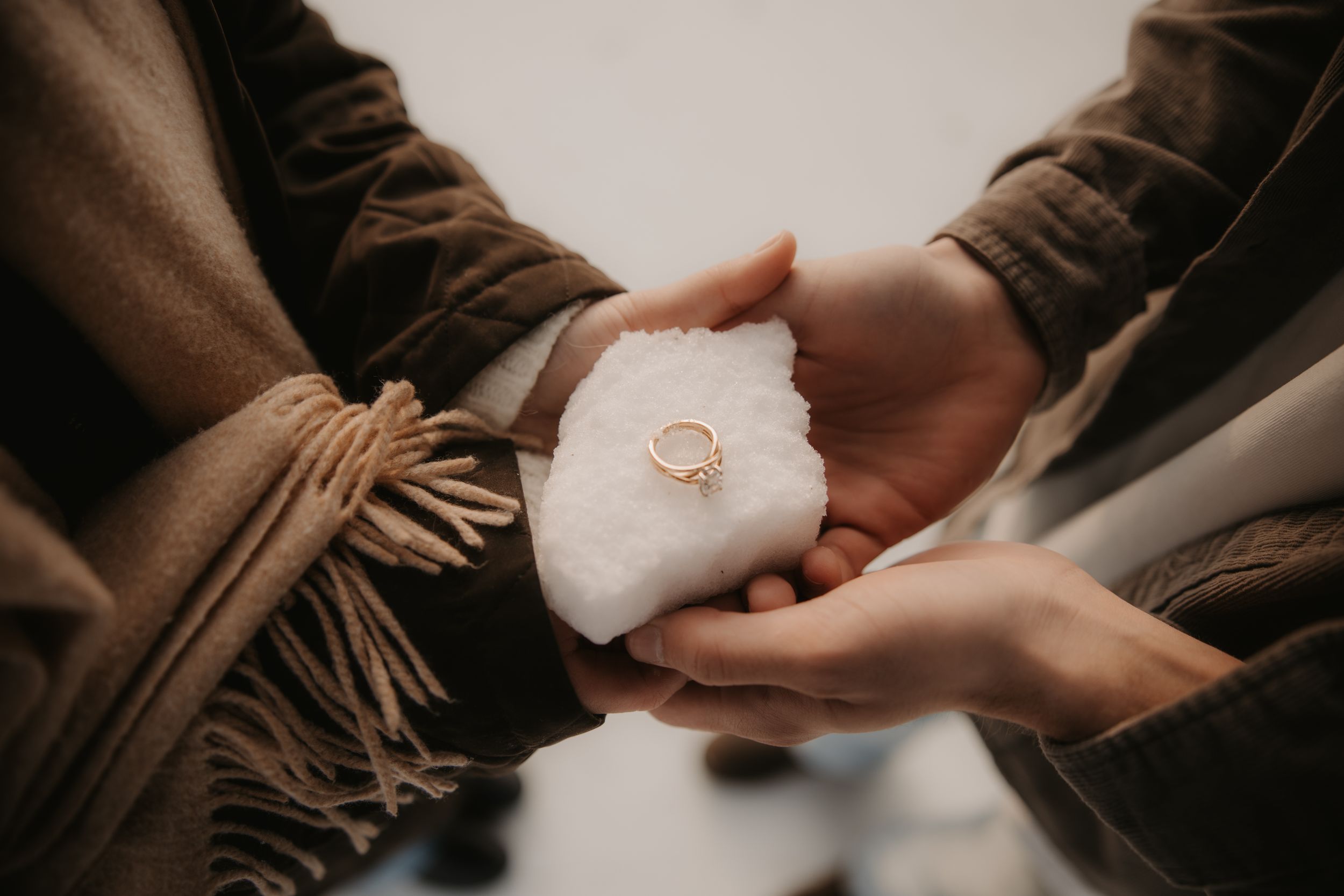 Close-up shots of hands exchanging wedding rings during an intimate ceremony in warm lighting.