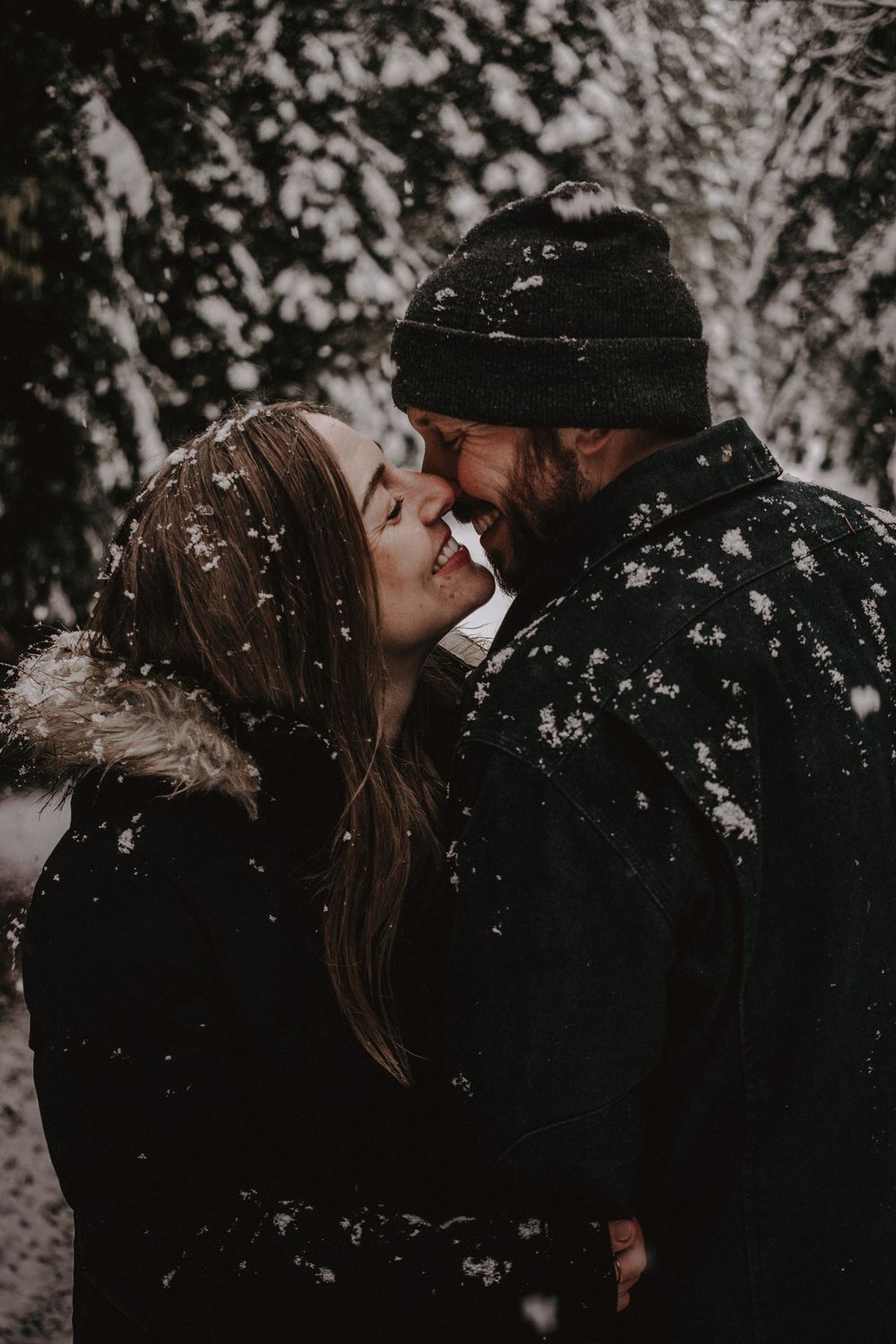 Couple sharing an intimate moment in the falling snow.