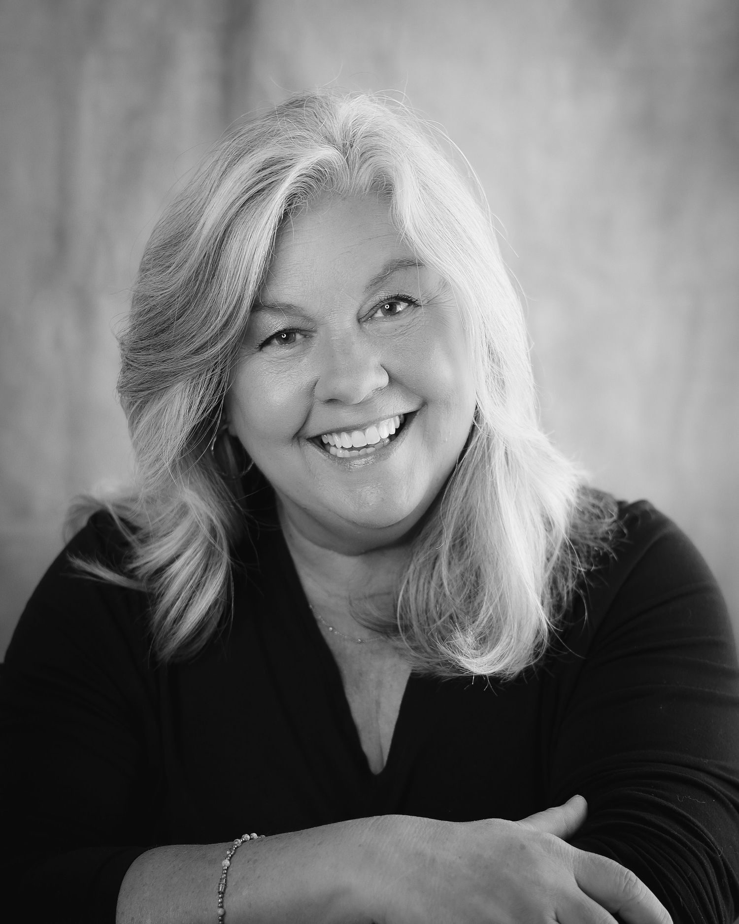 Black and white portrait series showing a person with light hair and a black top expressing joyful emotions.