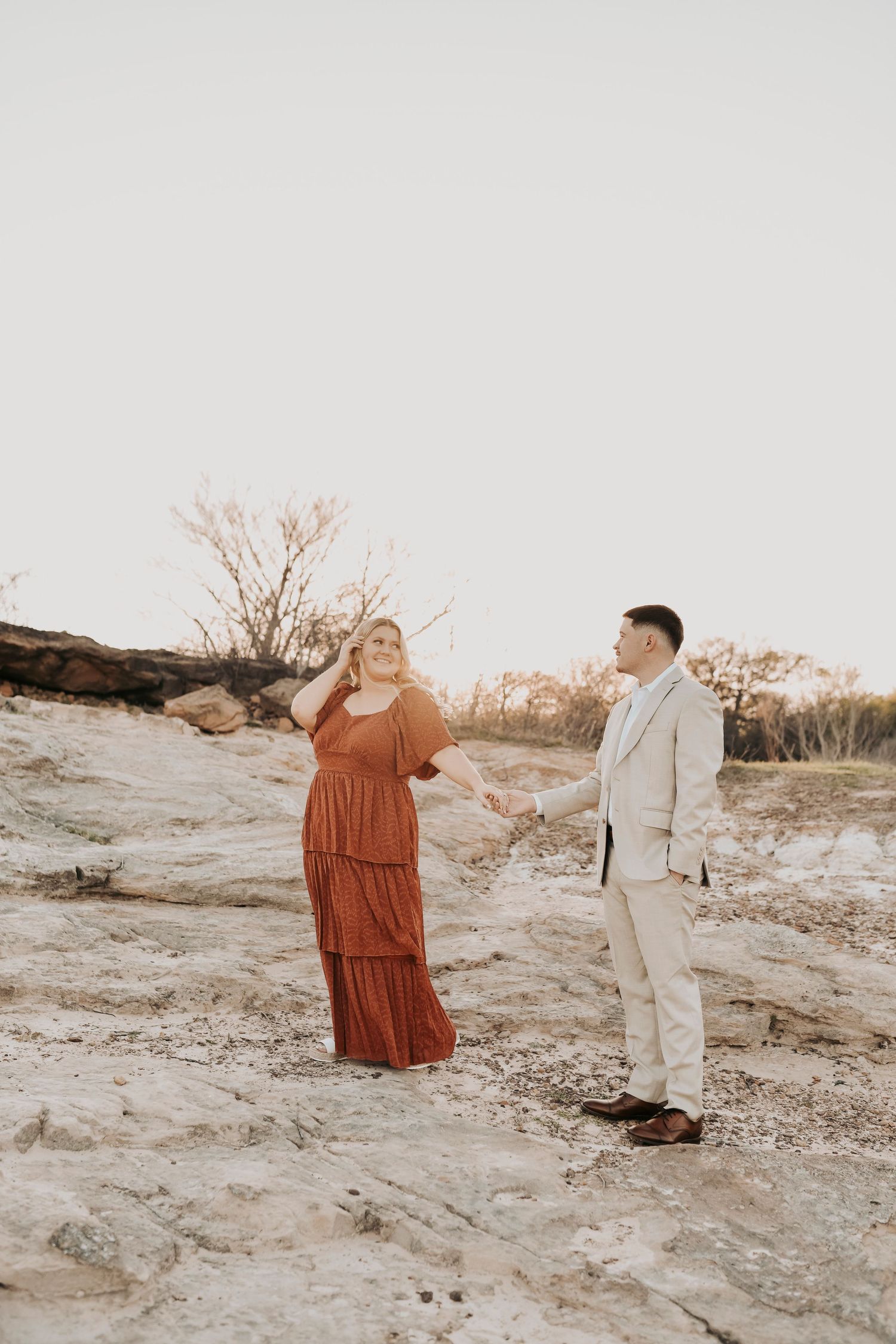 Couple spinning in field during Flower Mound engagement session.