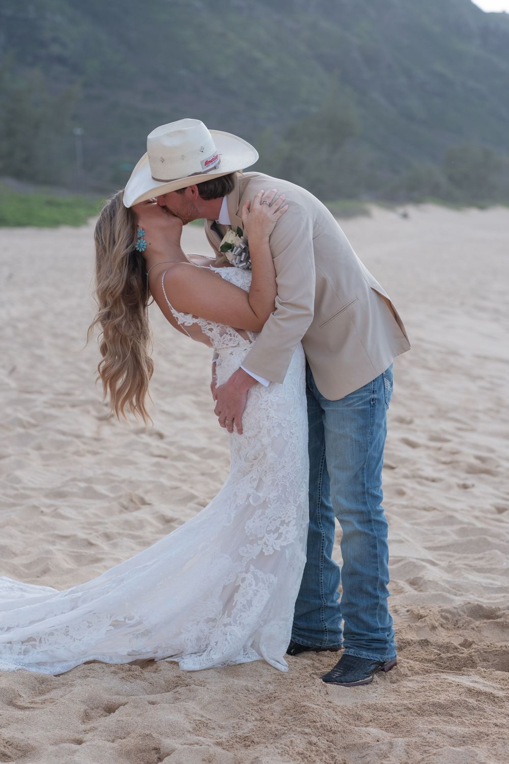 A couple embraces on a sandy beach during a romantic photoshoot on Oahu North Shore