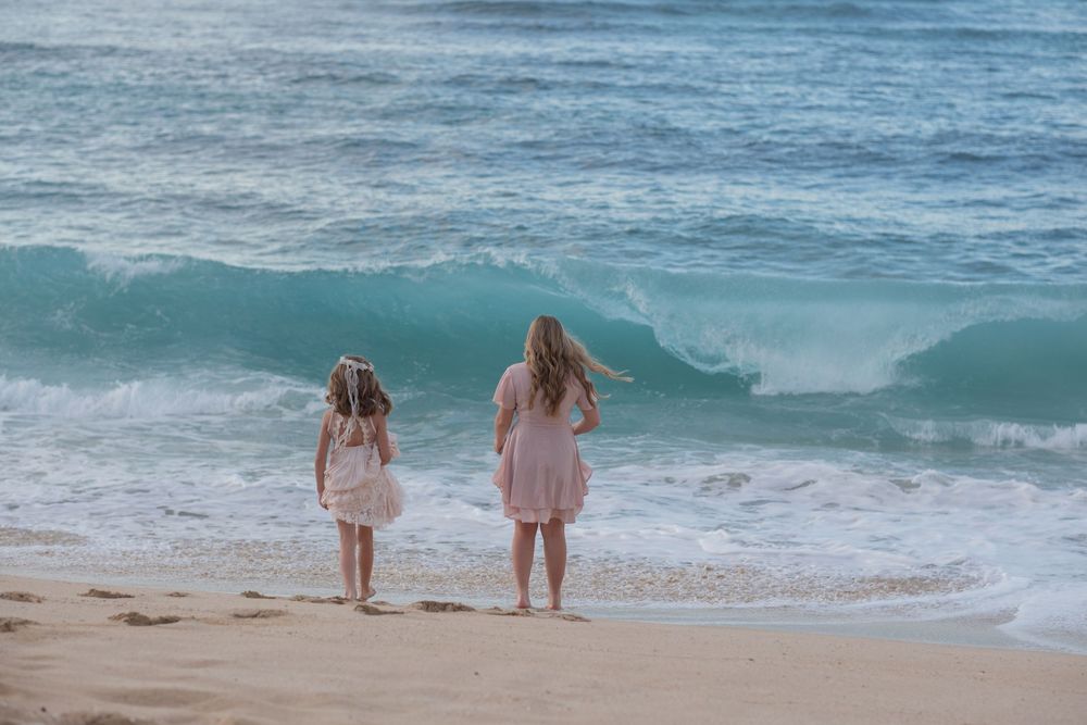 A romantic beach scene with waves crashing in the background during a romantic photoshoot on Oahu North Shore