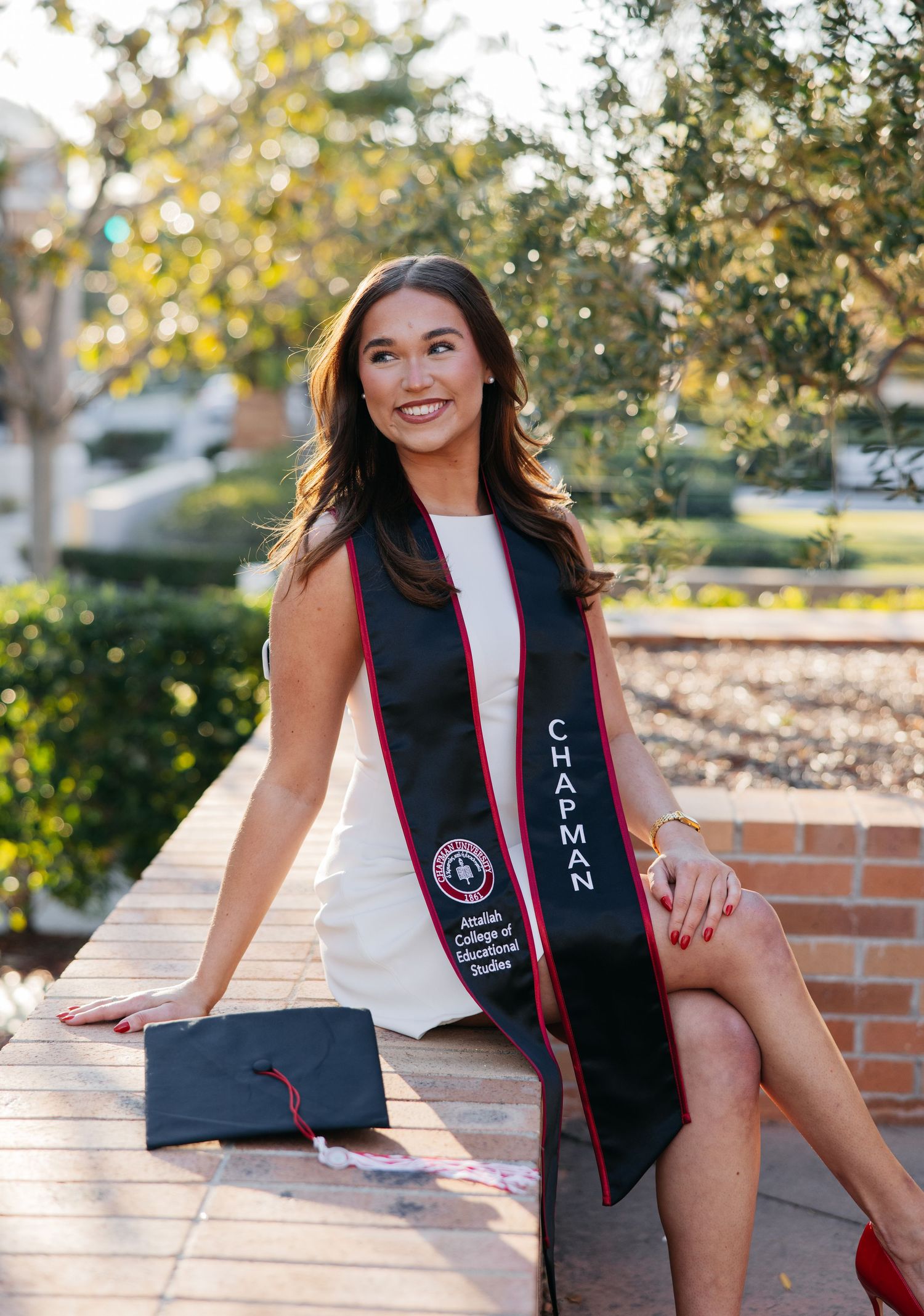 A series of graduation photos showing someone in a black graduation stole with pink trim posing outdoors on brick steps.