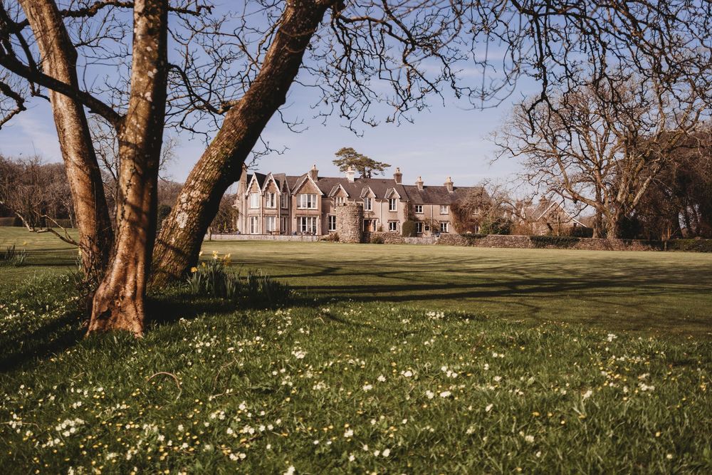Parc Le Breos wedding venue in Gower, West Wales with spring flowers on the lawns