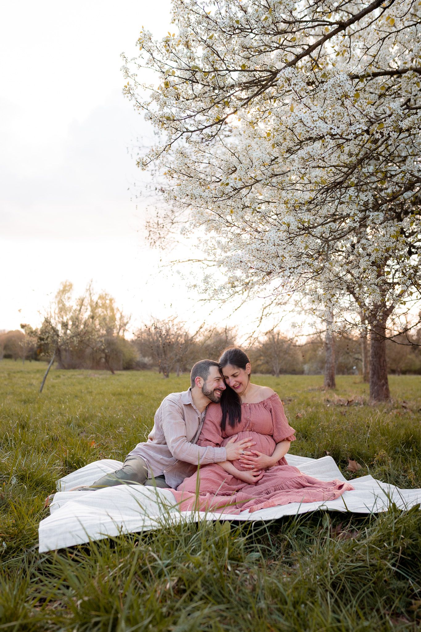Couple assis sous un cerisier en fleurs dans une ambiance douce et lumineuse au printemps