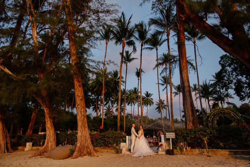 wedding couple standing on beach surrounded by palm trees at sunset Ban Suriya Koh Samui luxury villa wedding Thailand