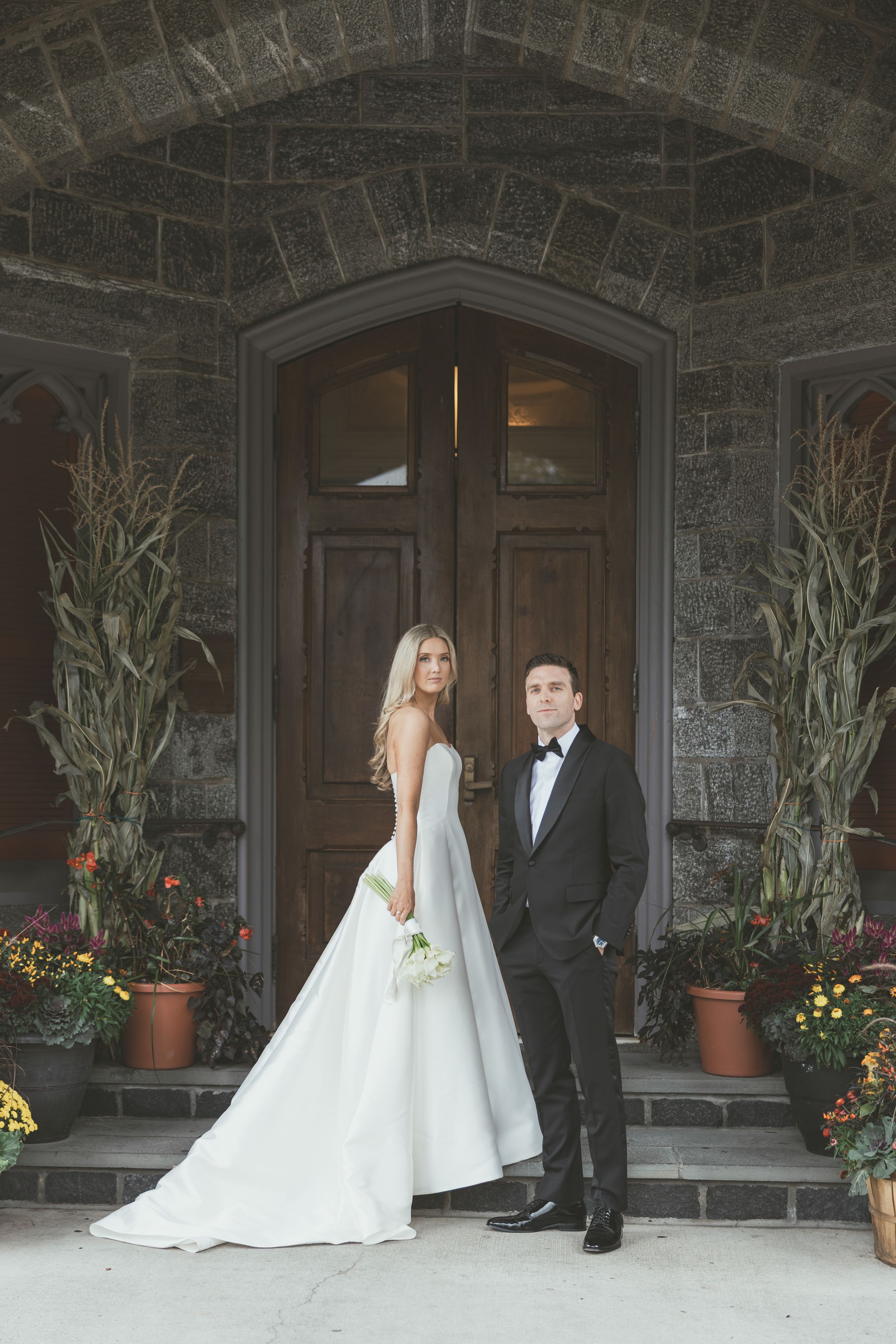 A series of wedding photos showing a couple posing in front of a stone church entrance with potted plants and flowers.