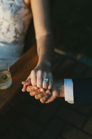 Close-up sequence of hands rolling white tape or bandage in dark moody lighting.
