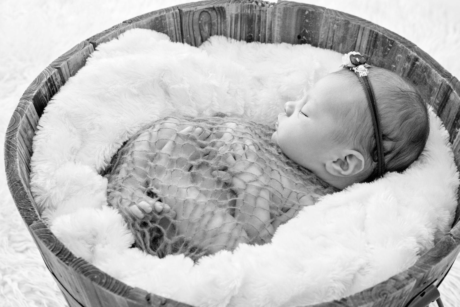 newborn baby in a wooden bucket for her newborn photography session pin the gold coast