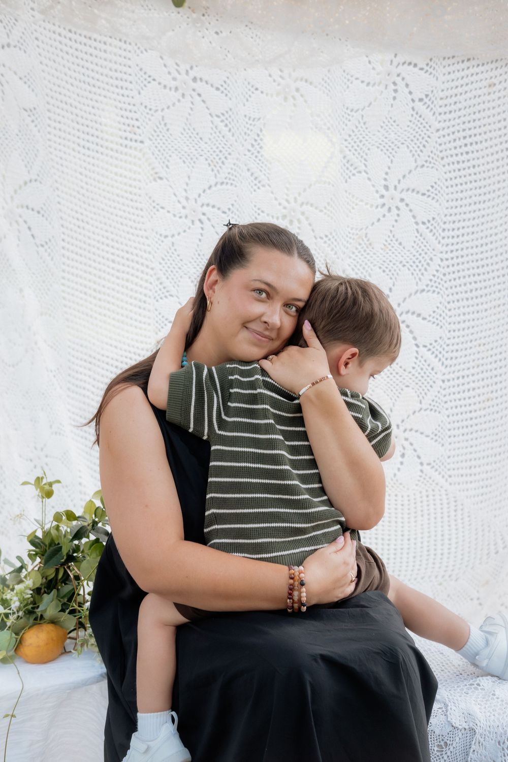 A tender moment captured in black and white against a lace backdrop showing affection and connection between two people.