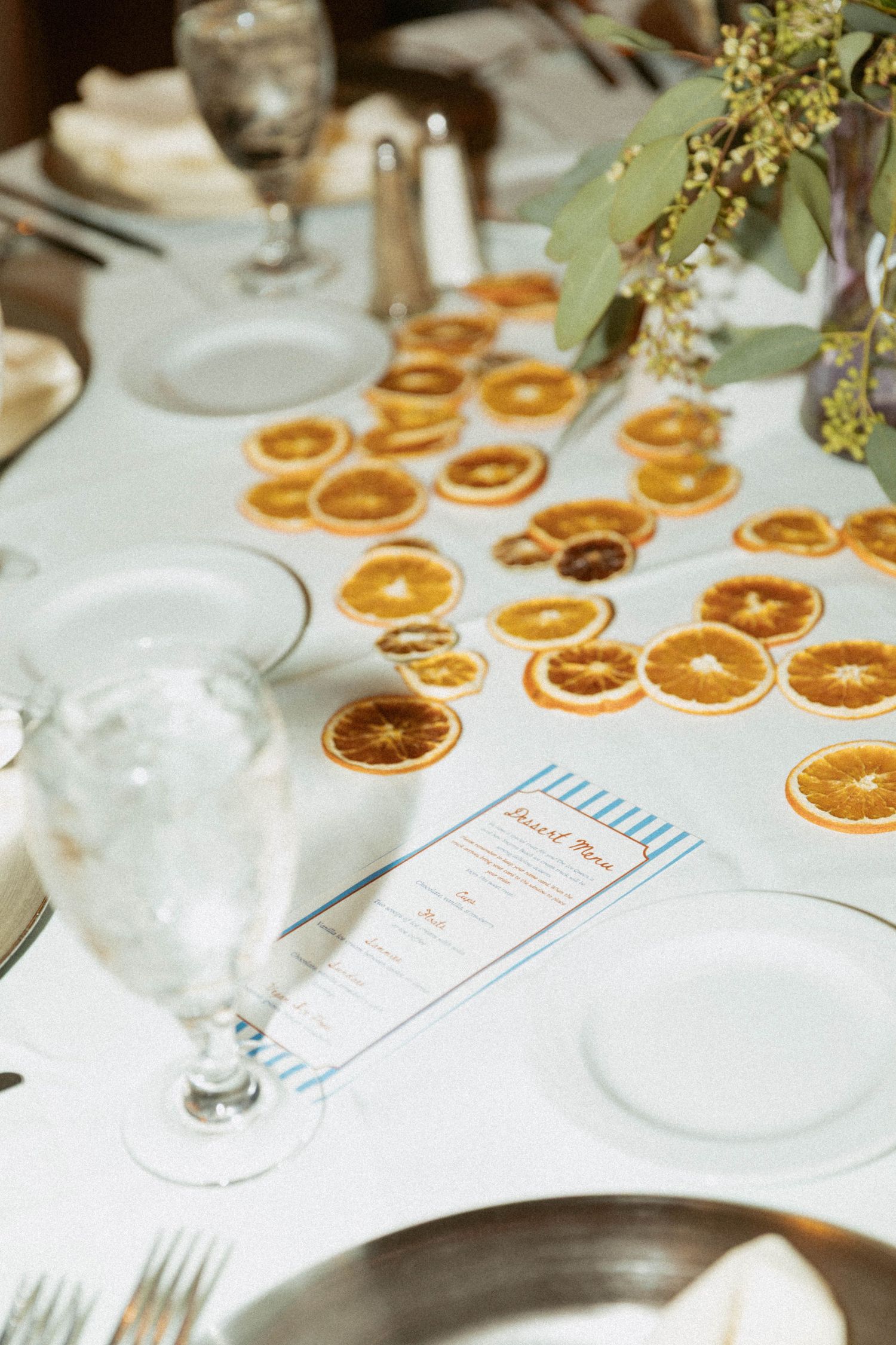 Guests gathered at a wooden bar counter with wine glasses and beverages enjoying a social celebration.