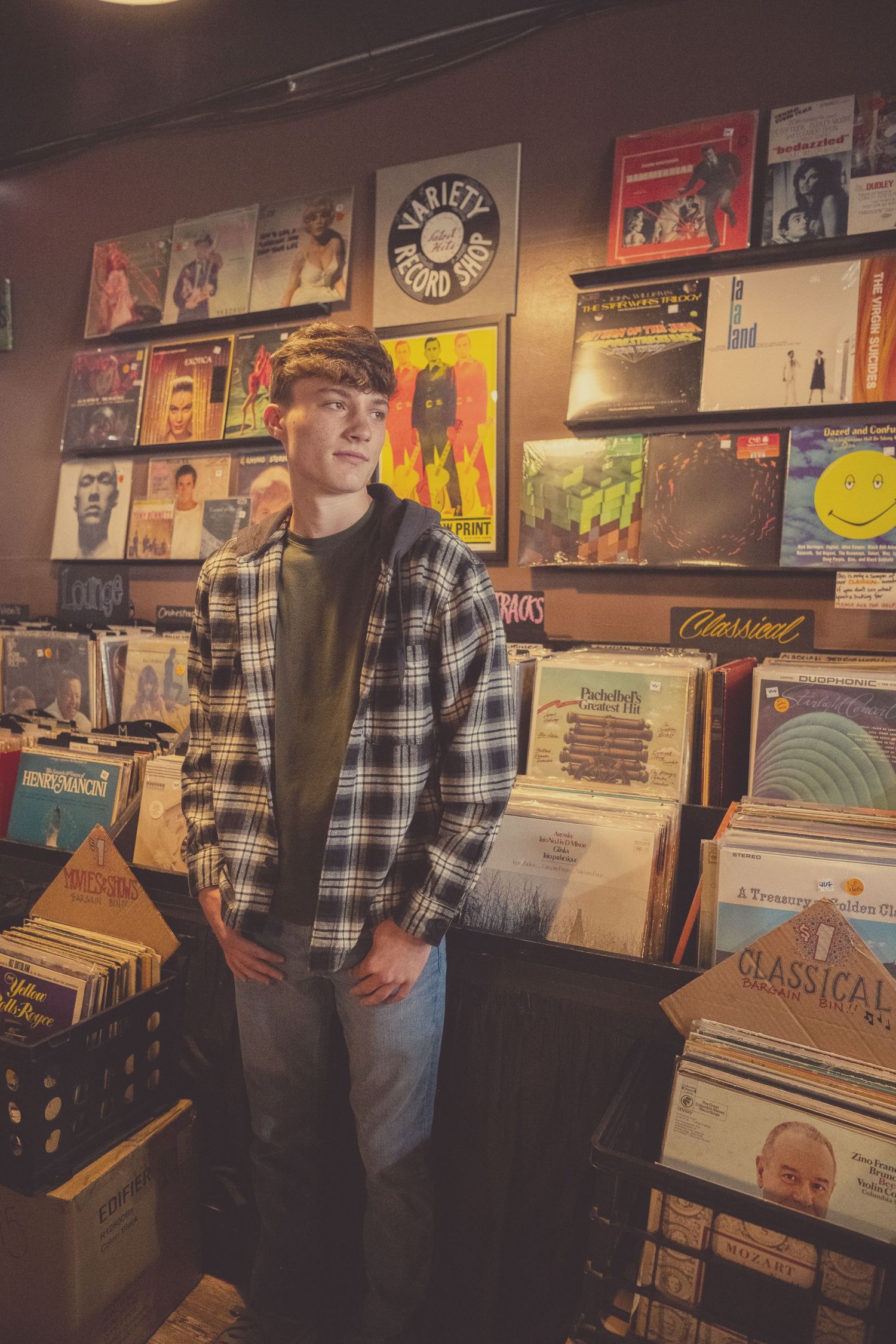 A record store interior with vinyl albums displayed on walls and in crates, featuring vintage music posters and memorabilia.