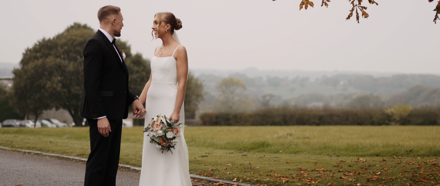 Scenic fall wedding portrait with rolling hills and country road in the background.