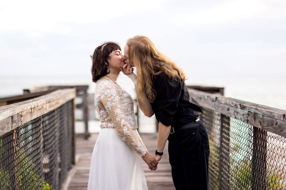 A romantic couple shares a tender moment on an urban rooftop with city views in the background.