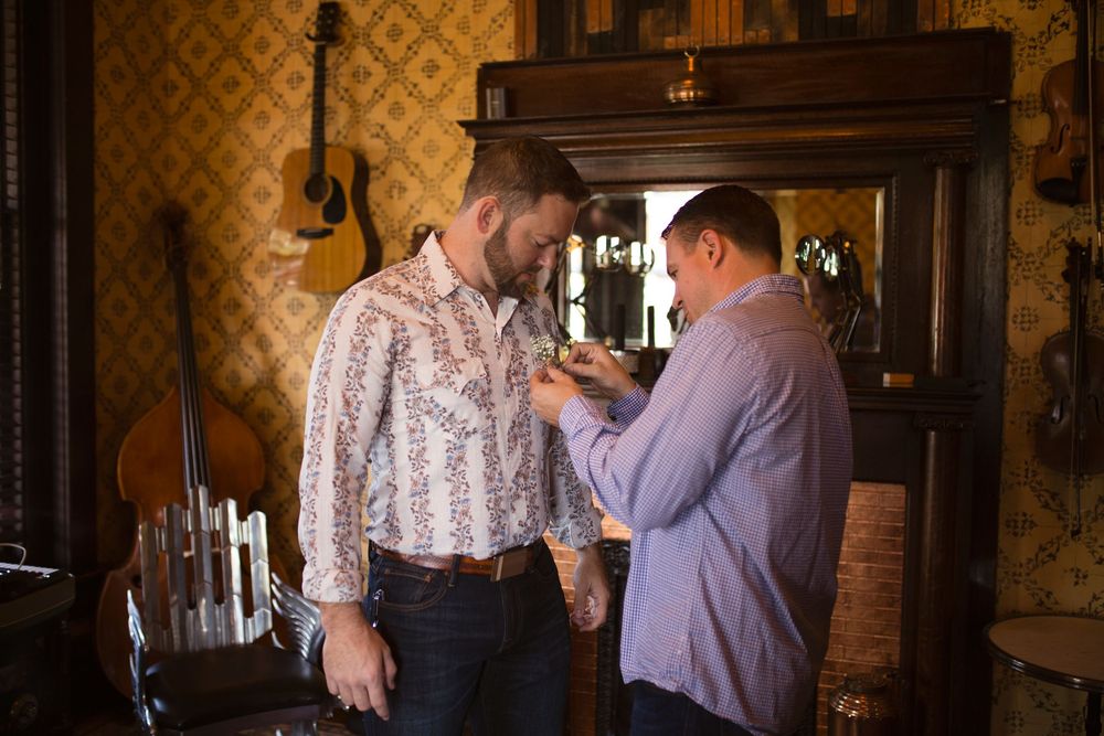 Three connected photos show people chatting and mingling at an elegant indoor event with ornate wallpaper and lighting.