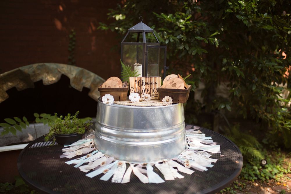 A series of white clothes pins arranged in a circular pattern around a metal pole in an outdoor garden setting.