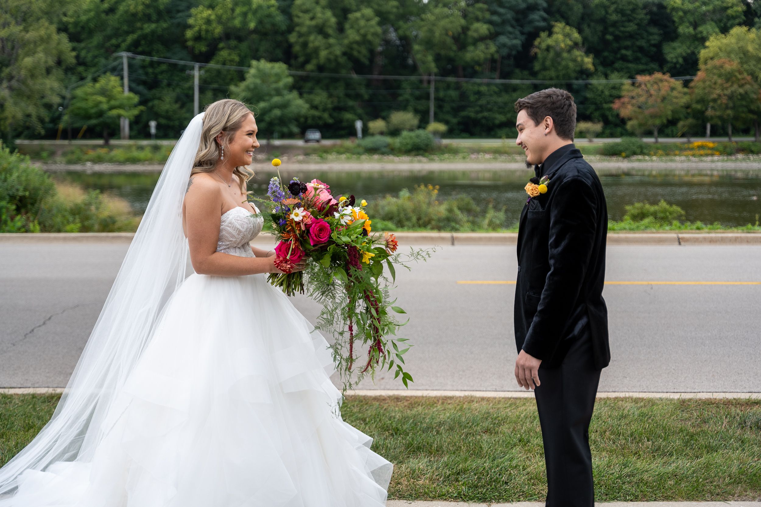 A couple shares a romantic moment during their wedding ceremony in a lush outdoor setting.