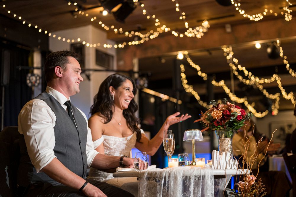 Wedding reception venue decorated with warm string lights and glowing chandeliers creating a romantic atmosphere.