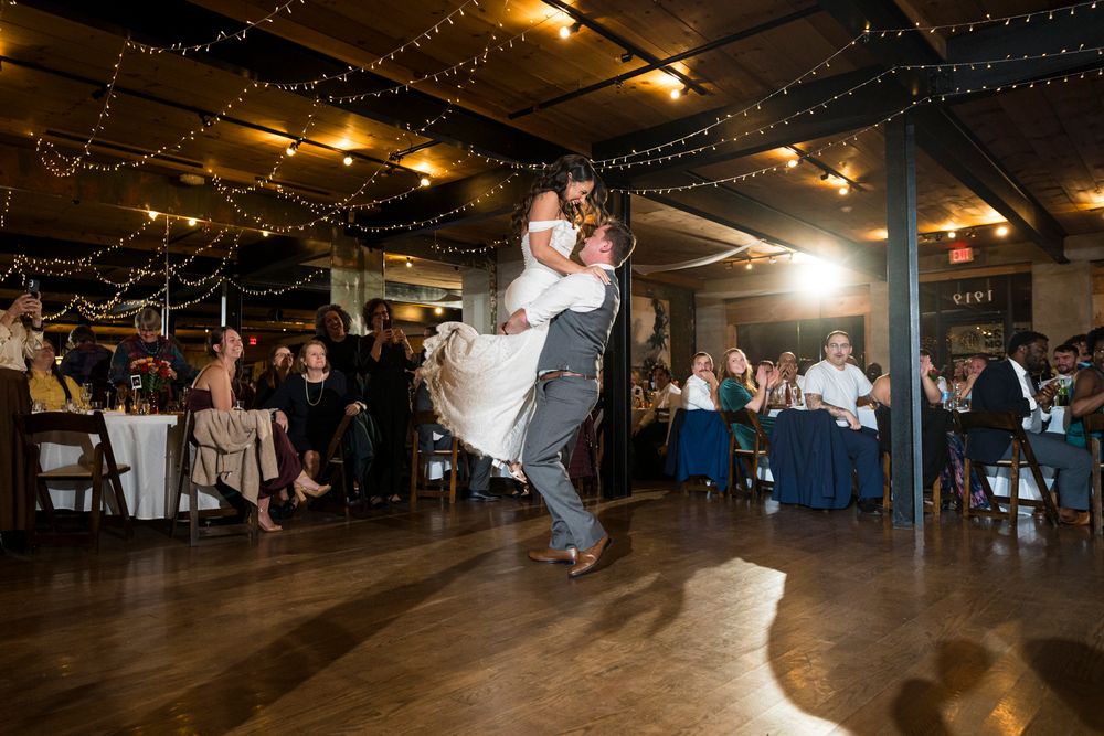 Couples dancing together on a wooden dance floor under warm lighting at a social dance event.