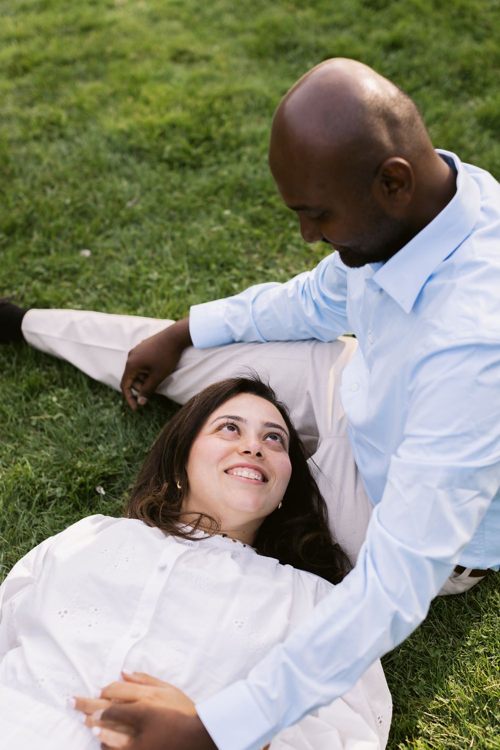 Woman in white dress lays head on man's lap wearing a blue shirt or couple photos. Concord, Hampton, Dover, couple photographer