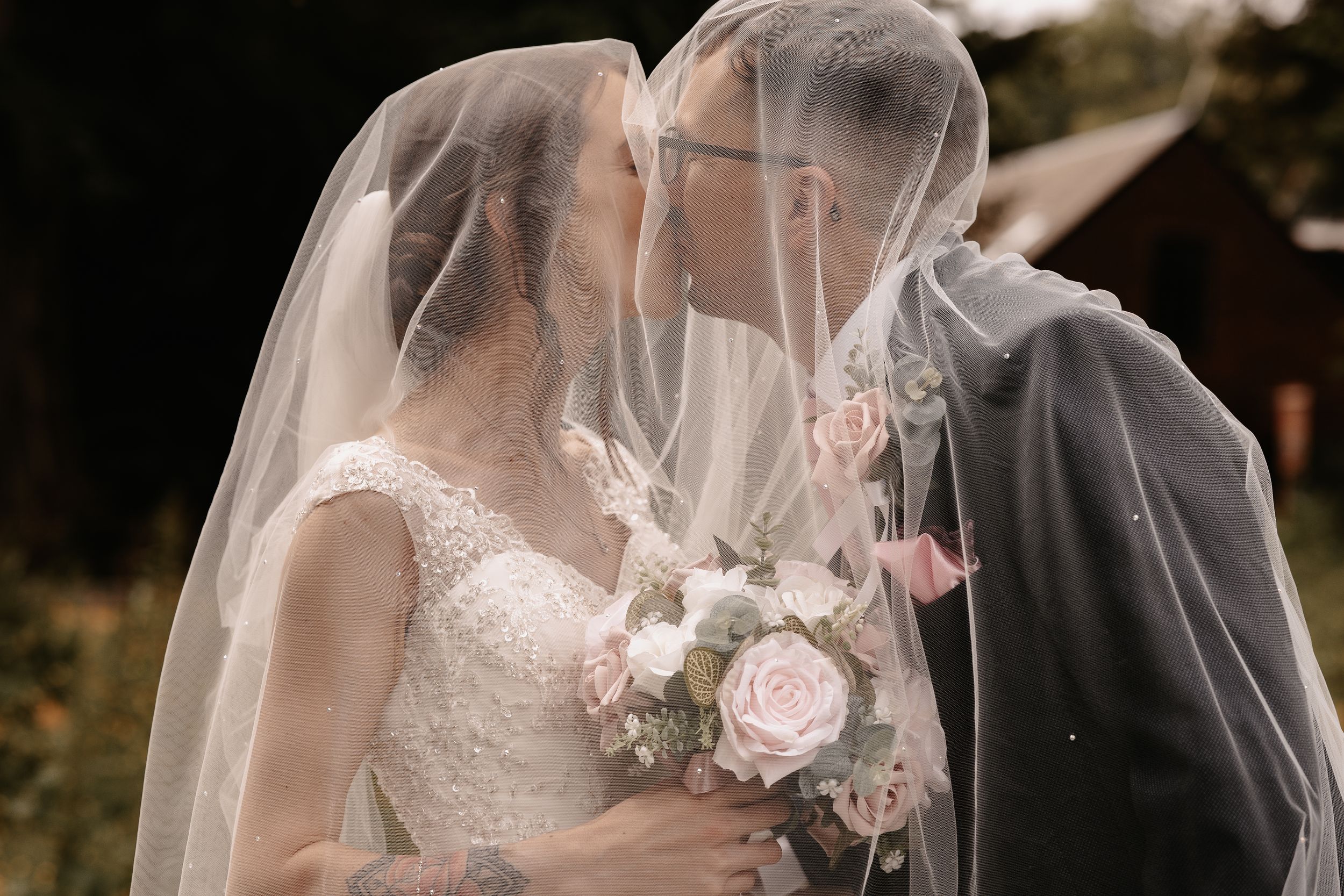 A wedding couple embraces under a white lace veil in a romantic photo montage against natural outdoor backgrounds.