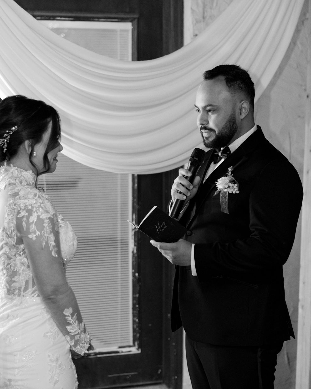 Bride and groom sharing an intimate moment during wedding ceremony in black and white
