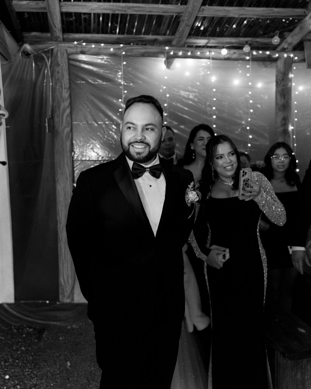 Groom walking confidently during wedding reception, candid black and white moment