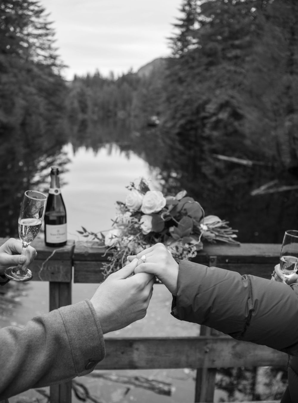 Close-up of gloved hands holding floral bouquets against winter mountain scenery.