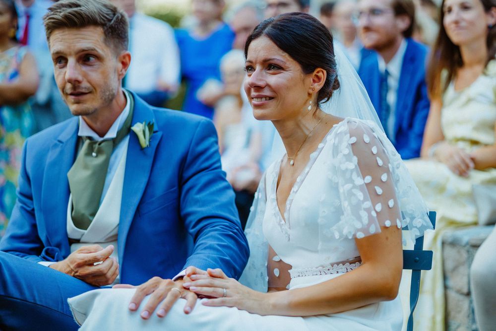 Guests seated at an outdoor wedding ceremony with blue and white decor.