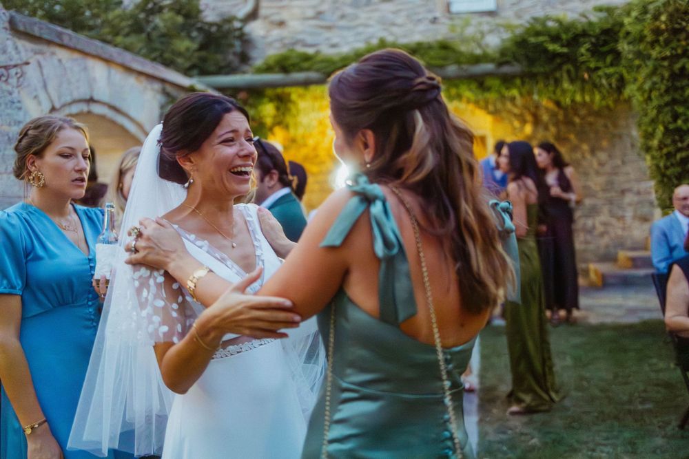 Joyful wedding party dancing and celebrating outdoors with colorful attire and natural lighting.
